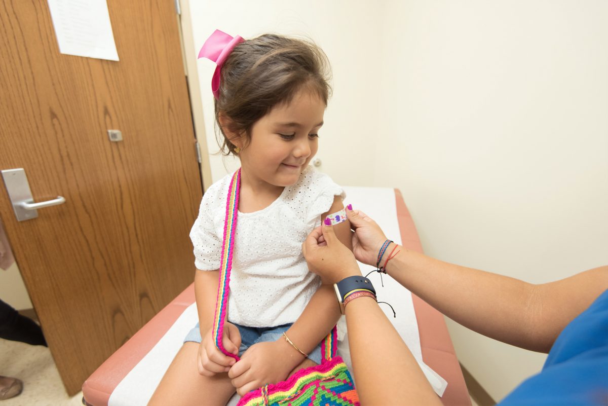 Little girl getting her bandaid put on her arm
