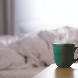 mug of tea next to an empty bed