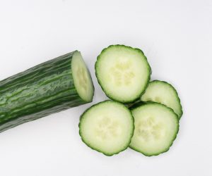 cucumber and cucumber slices against a white backdrop