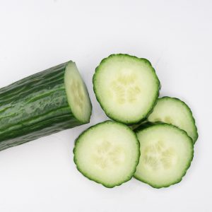 cucumber and cucumber slices against a white backdrop