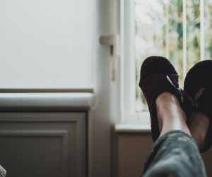 person lounging with their feet in slippers