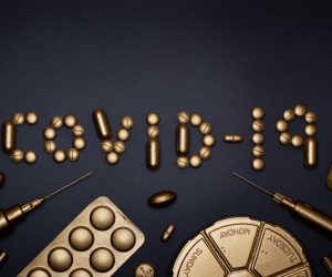 COVID-19 written in gold sprayed pills