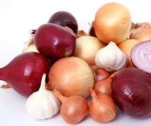 pile of various onions against a white backdrop