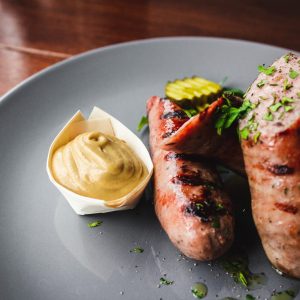 cooked sausage on a plate with mustard