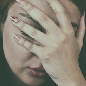 woman holding her head in pain