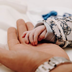 newborn infant hand in an adult hand