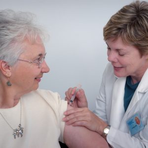 older woman getting a shot from a doctor