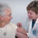 older woman getting a shot from a doctor