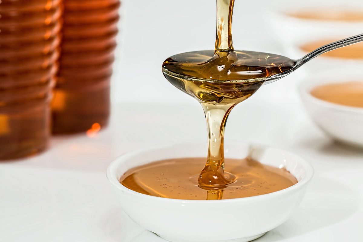 Honey being poured onto a spoon and into a bowl