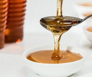 Honey being poured onto a spoon and into a bowl