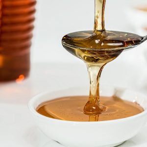 Honey being poured onto a spoon and into a bowl