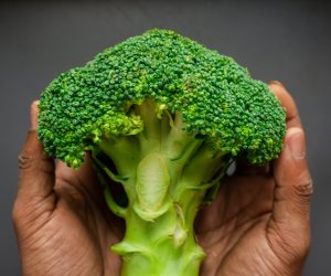 person holding broccoli floured in hands