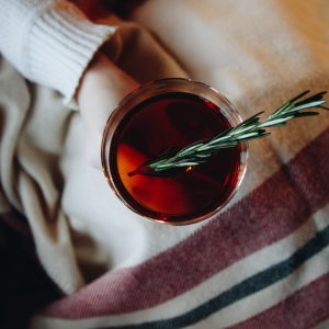 a person holding a mug of rosemary tea